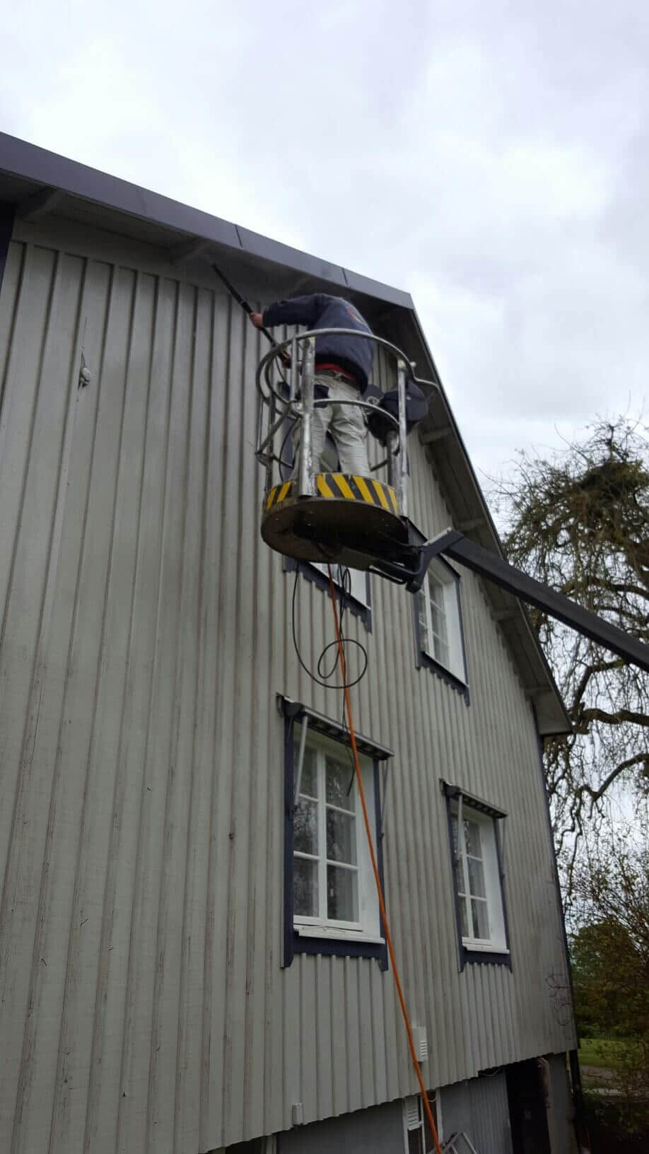 Fasadmålning av trähus med skylift