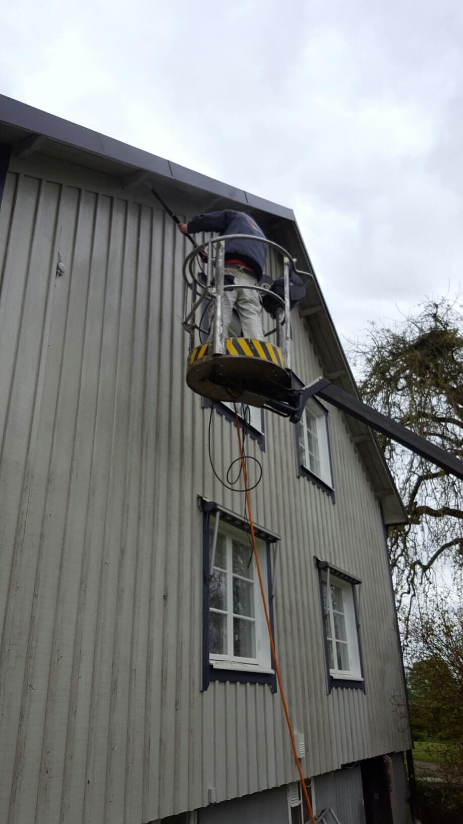 Fasadmålning av trähus med skylift