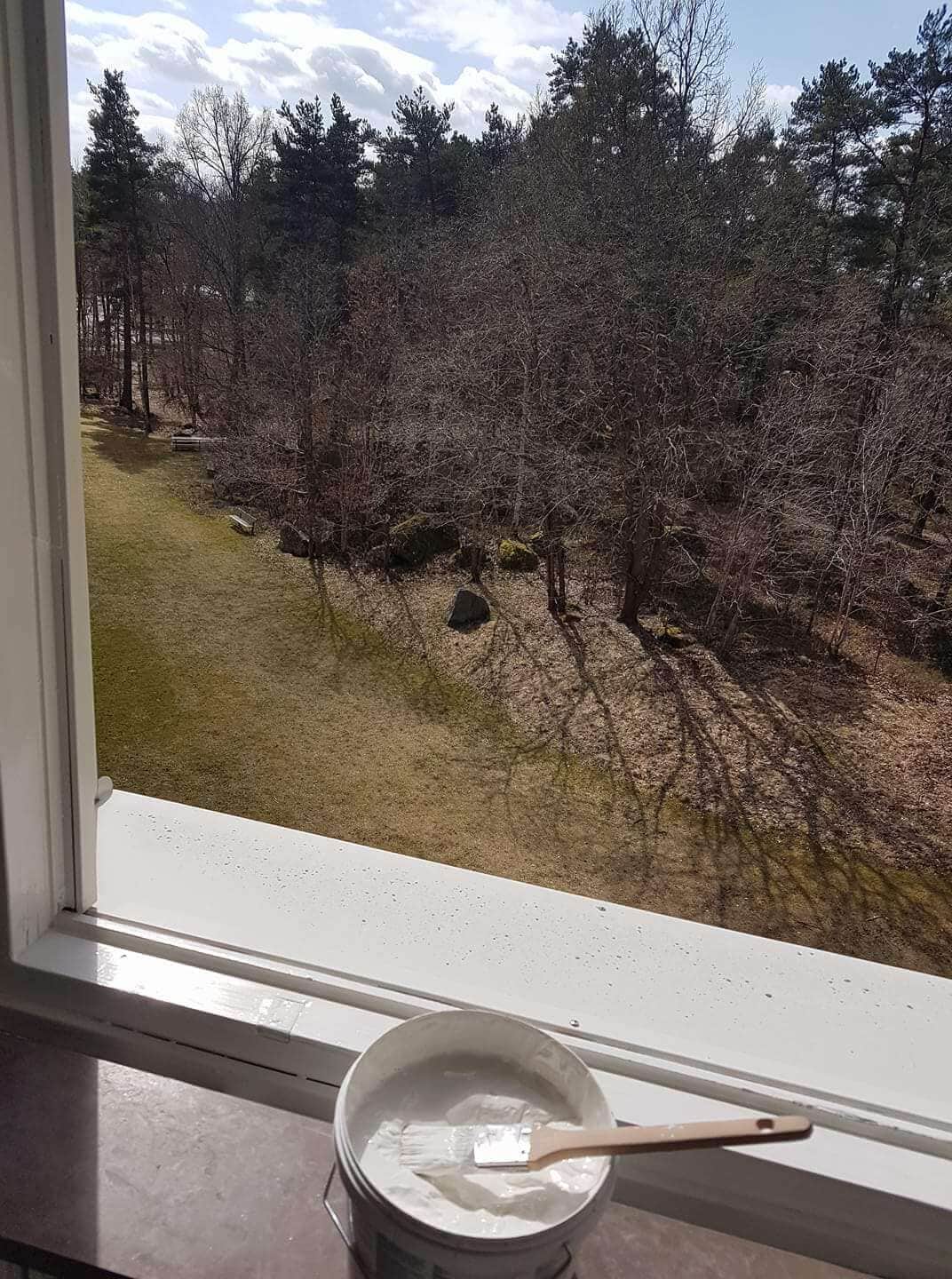 Nymålad fönsterkarm med färgburk och pensel