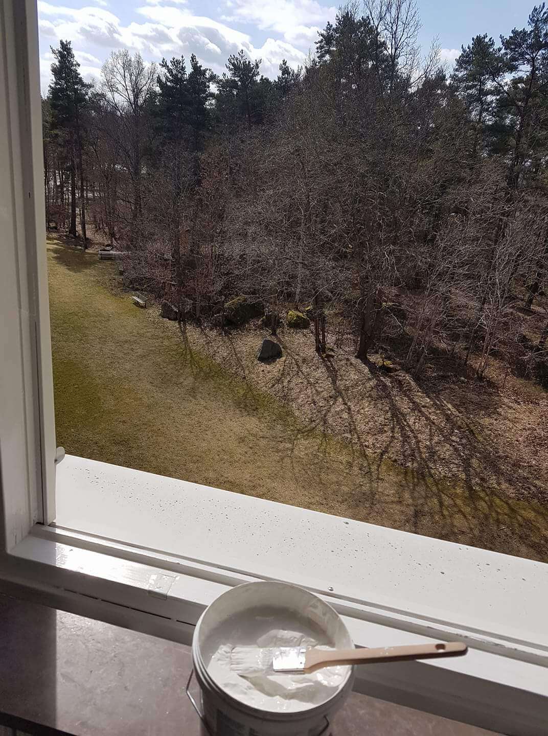 Nymålad fönsterkarm med färgburk och pensel