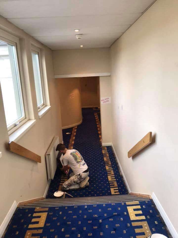 Målare arbetar i hotellkorridor
