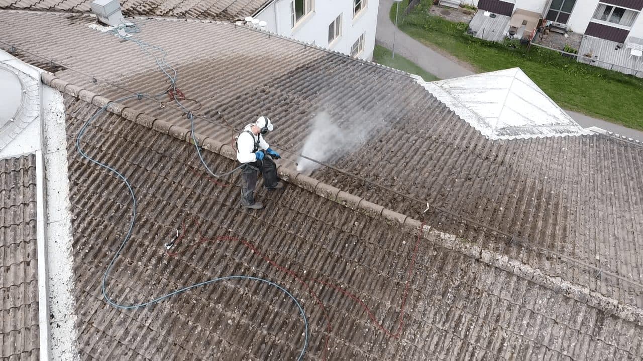 Målare högtryckstvättar betongpannor på flerbostadshus