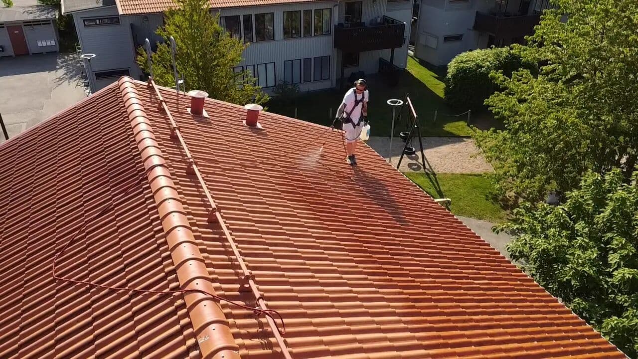 Målare tvättar tegeltak, drönarbild