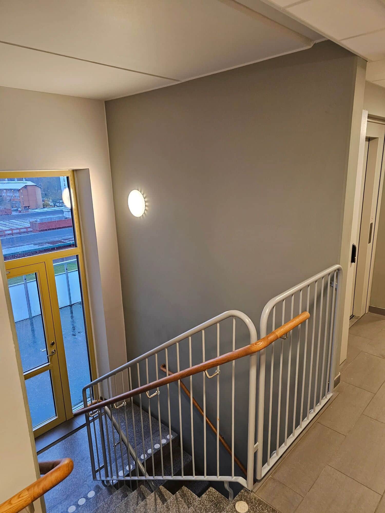 Nymålat trapphus i flerbostadshus med grå fondvägg