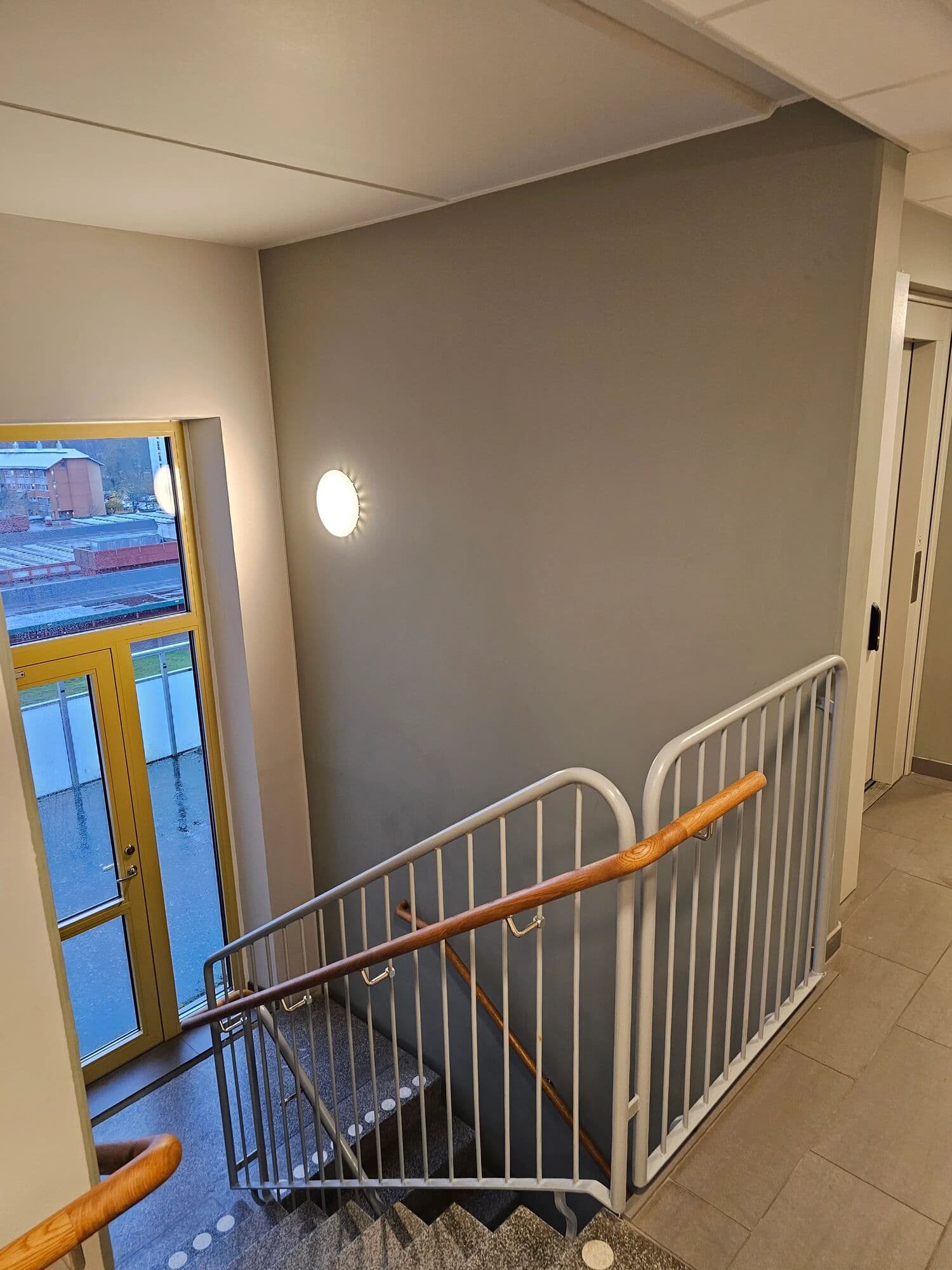 Nymålat trapphus i flerbostadshus med grå fondvägg